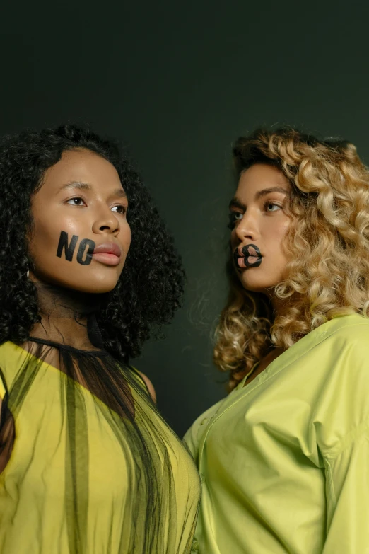 two women with no words painted on their faces