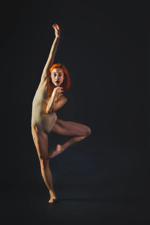 an artistically dressed woman posing in front of a black background