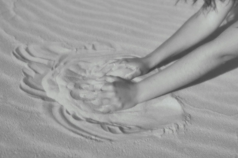 a black and white po of two people on the sand