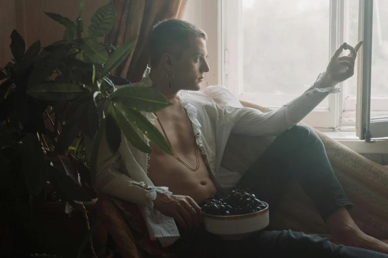 a young man sitting on a couch with a remote control in his hand