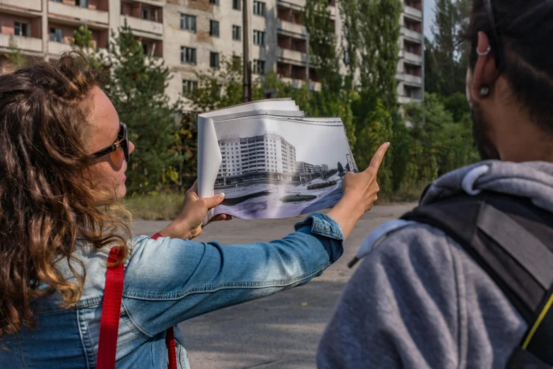 a woman showing a po to another woman holding up an architectural design