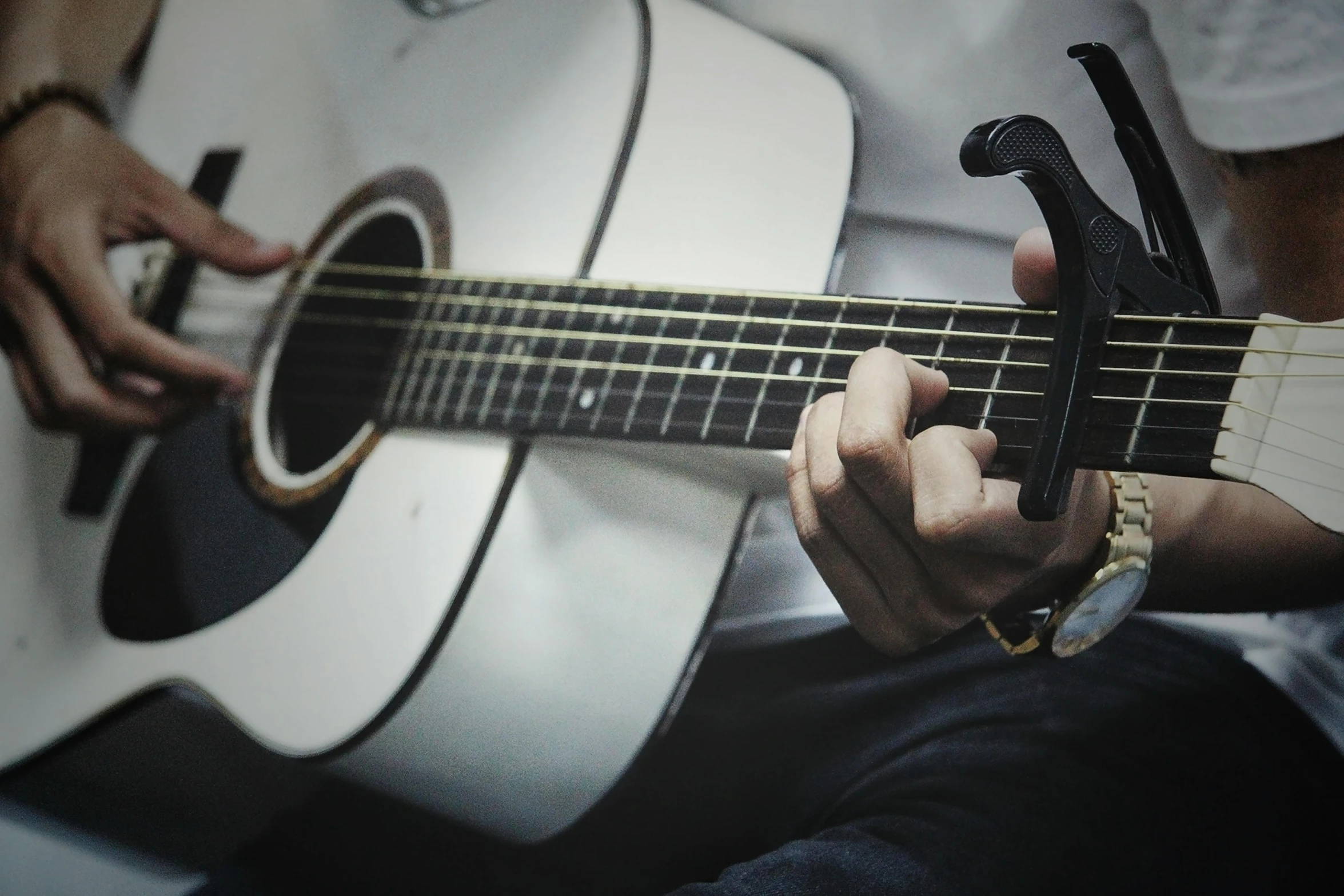 a man holding a guitar has his finger on the tuner