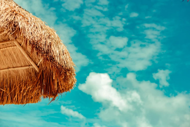 a parasol under the blue sky and clouds