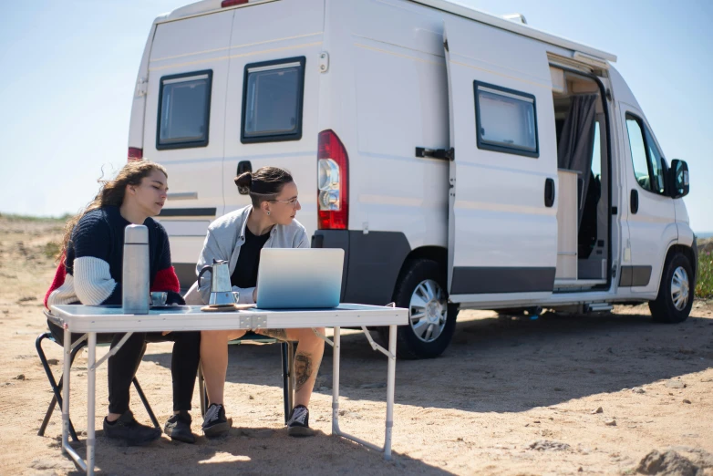 two people are outside at a table in the middle of a desert