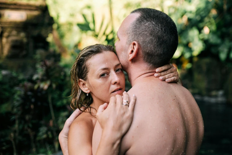 a man and woman with wet arms emcing each other