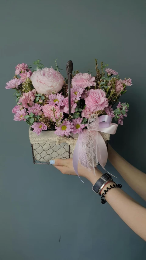 pink flowers in a basket on a blue background