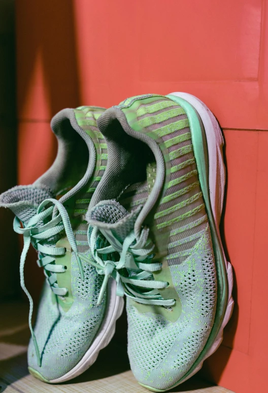 green and grey running shoes on red tiled floor