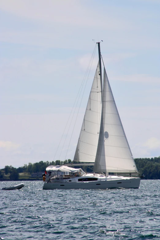 a white sail boat sailing on top of a lake