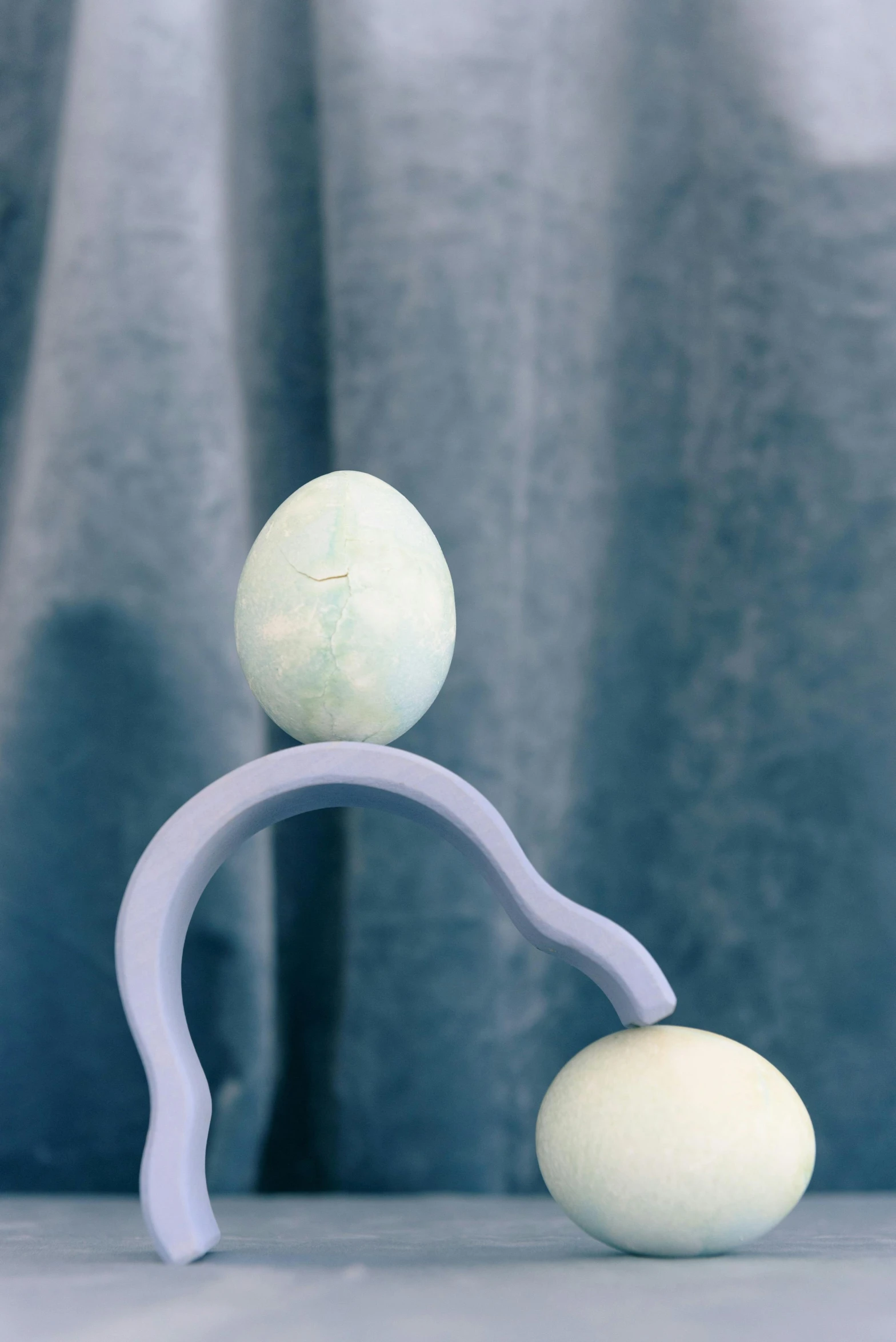 a blue and white model has one egg placed in front of another