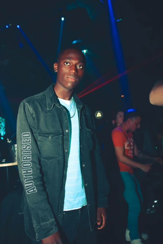 a black guy standing with lights and jacket