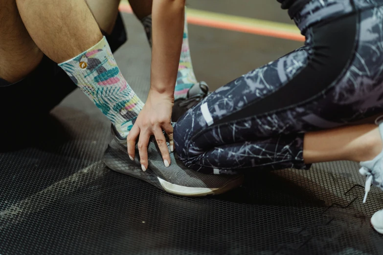 a group of people in colorful socks are tying their shoes