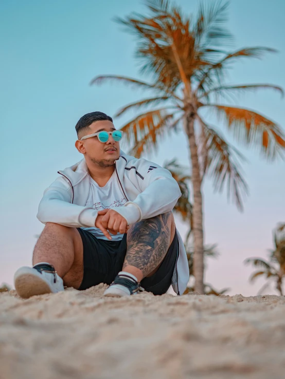 a man sits on the sand looking away