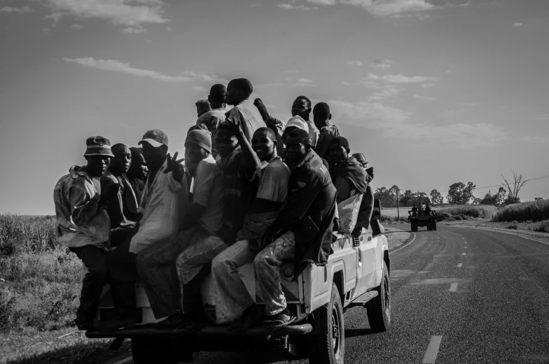 black and white pograph of several people in the back of a truck