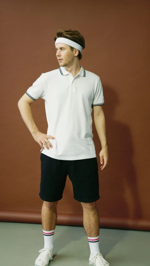 a man poses for a picture wearing tennis clothes