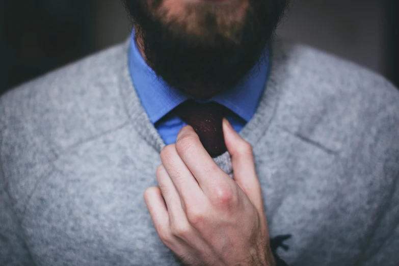 a man is adjusting his tie with his hands