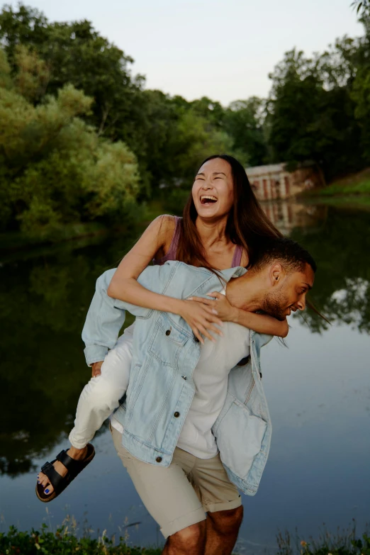 a woman is carrying a man over her head