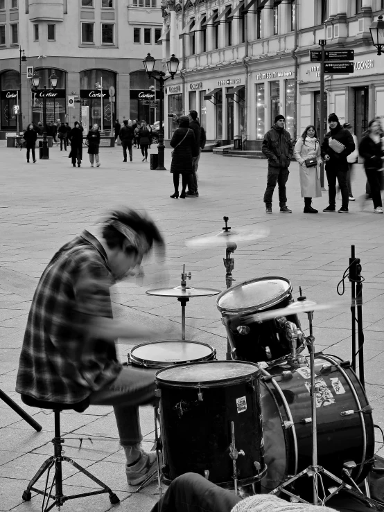 a drummer is playing drums outside on the street