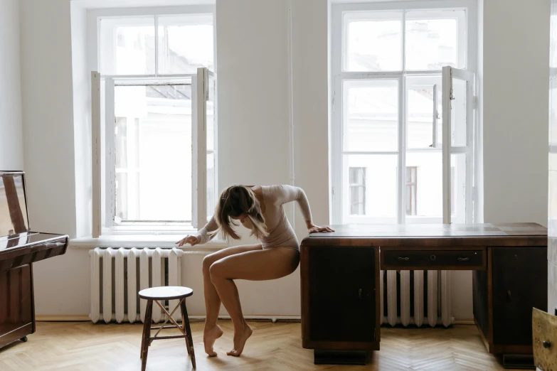 a woman wearing no clothing posing in front of a desk