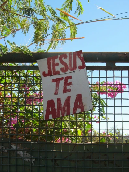 a sign hanging in front of a fence
