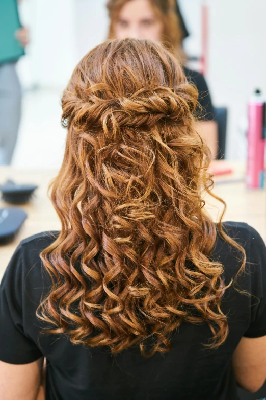 a beautiful woman with long curly hair sitting in front of a man