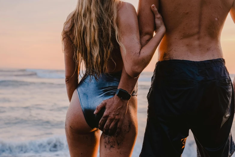 man and woman in swimsuit standing near the ocean