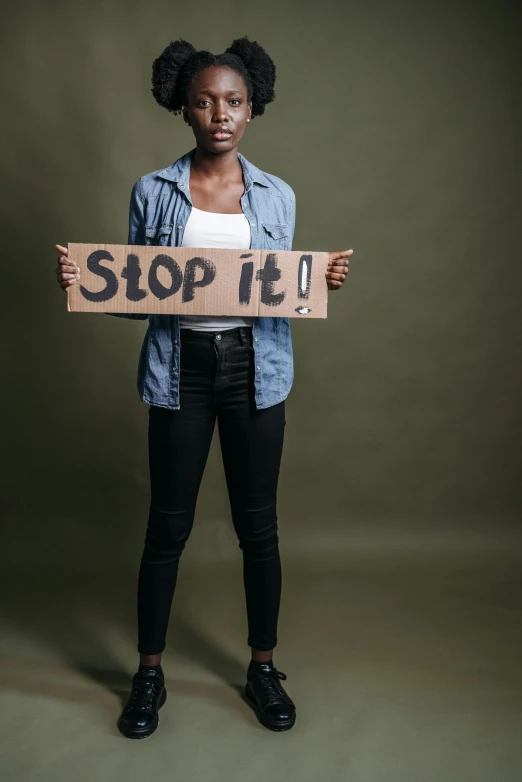 a woman holding a sign that says stop it