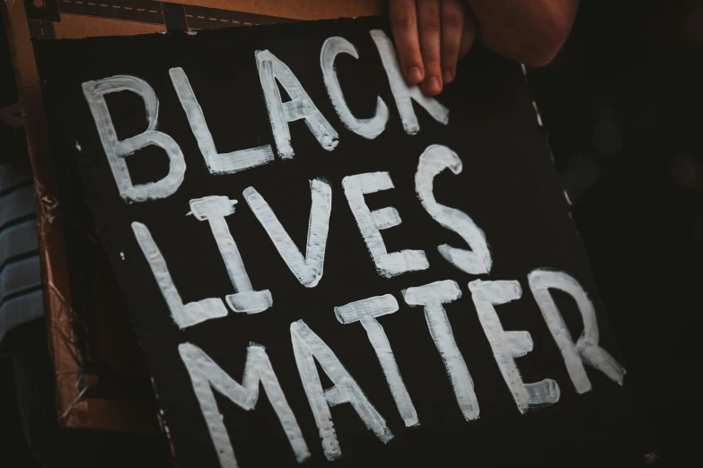 a black sign that reads black lives matter in white letters