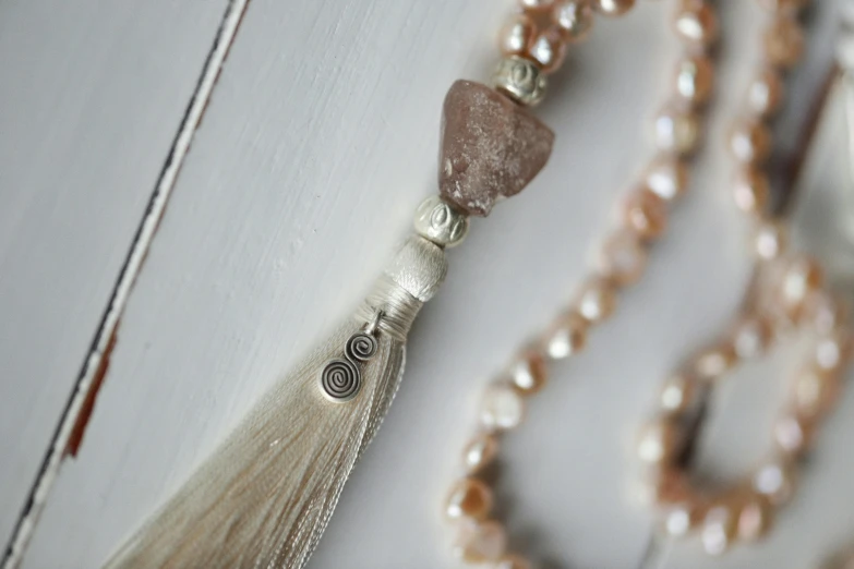 a necklace with a tassel of beads and a bead cord