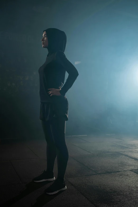 a woman with black clothes is standing at night