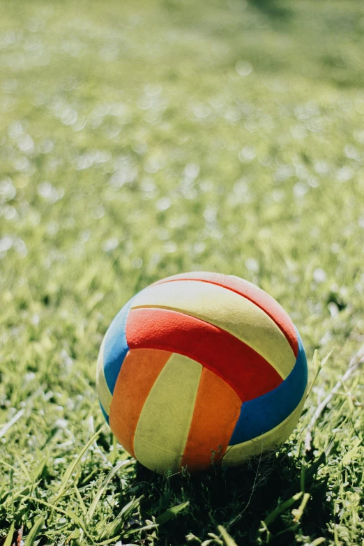 there is an orange and blue volleyball on the ground