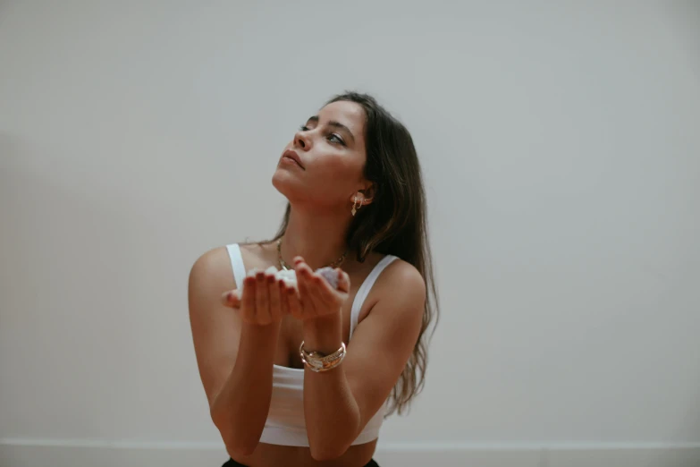 a woman looks upward while holding her hand to her chest