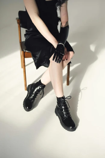 a person sitting on a chair wearing a pair of leather shoes