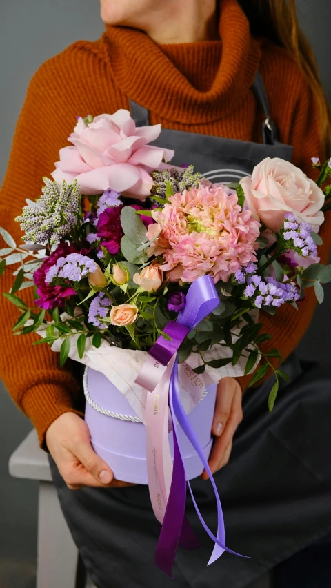 a person holding a small vase with flowers