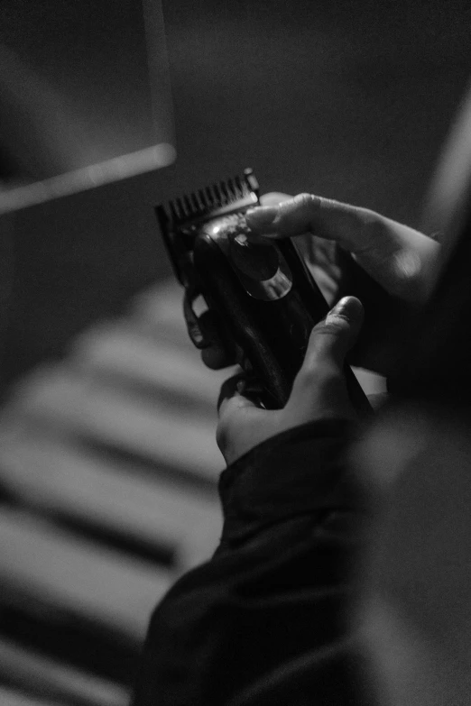 a man holding soing in his hand while using a hair brush