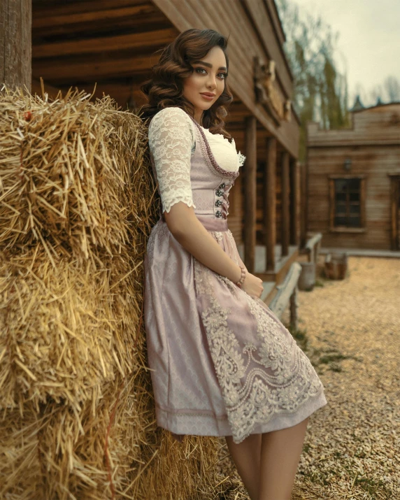 there is a woman that is standing next to hay