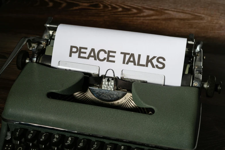 a typewriter with a piece of paper that reads peace talks