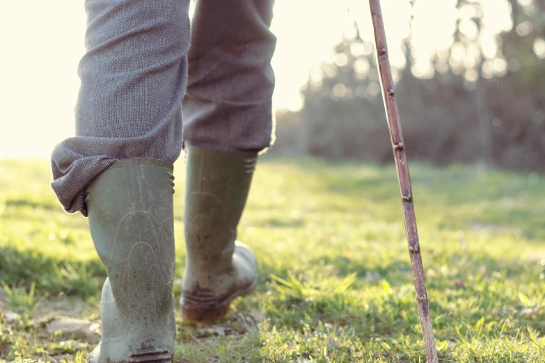 a pair of muddy legs are wearing green boots