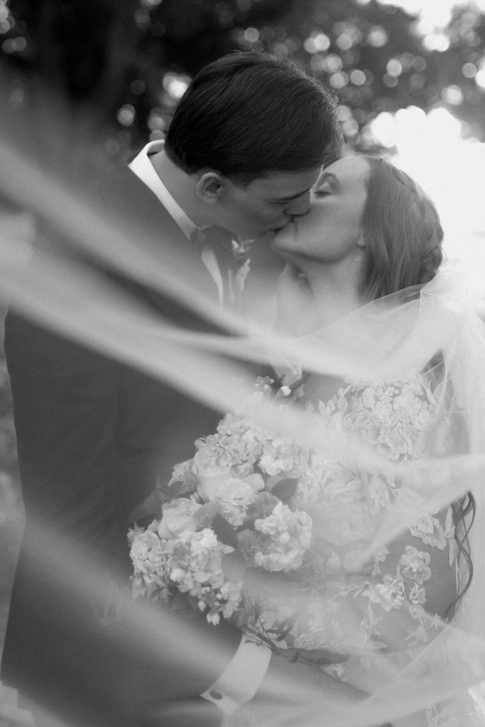 a couple kissing with each other in black and white