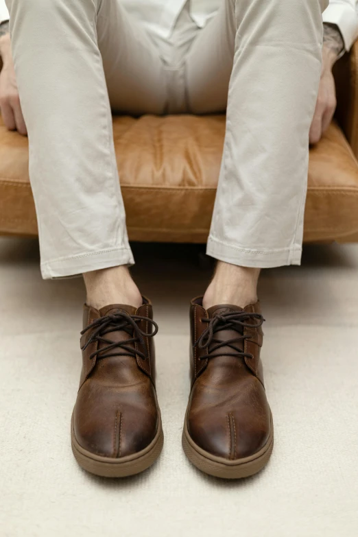 a person sitting on a chair with one foot in their shoes