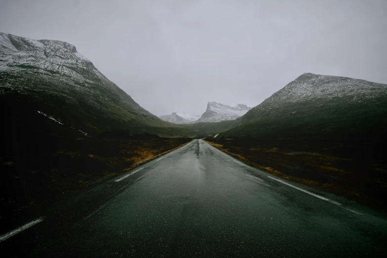 the dark and gloomy road stretches along a hill