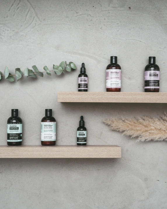 several bottles of liquid sit on top of shelves