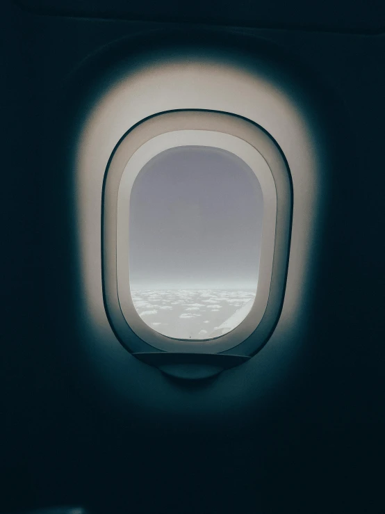 a plane window with clouds seen from inside