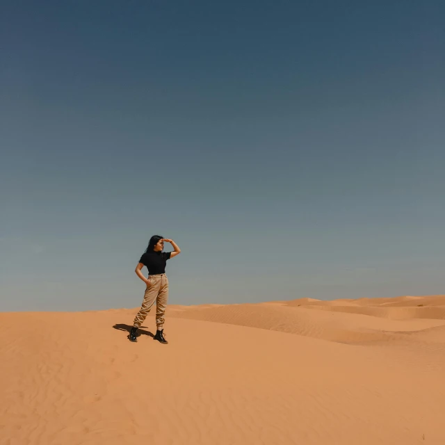 a man skateboarding in the sand on a clear day