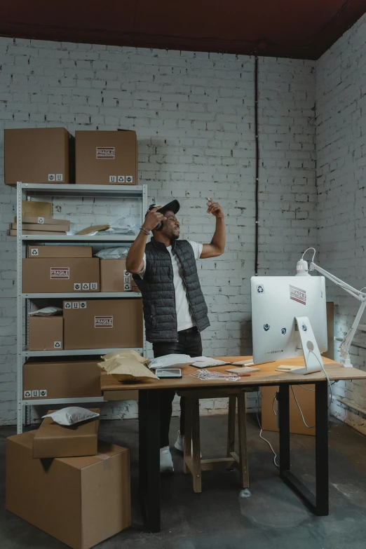 a man in a building holding up his hand to take a picture of a computer