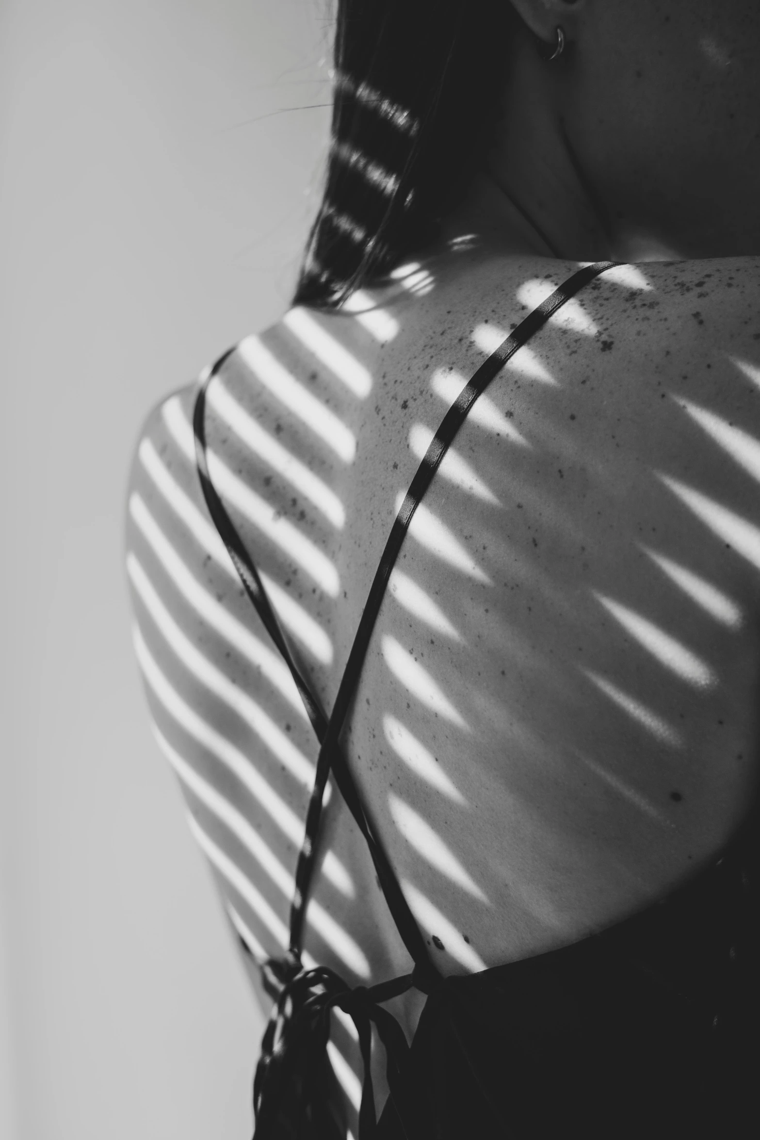 a women with her hair in a ponytail wearing a striped shirt