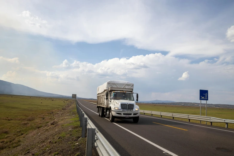 a truck is driving down the road in the daytime