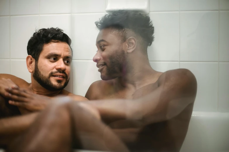 a pair of men sitting in a bathtub