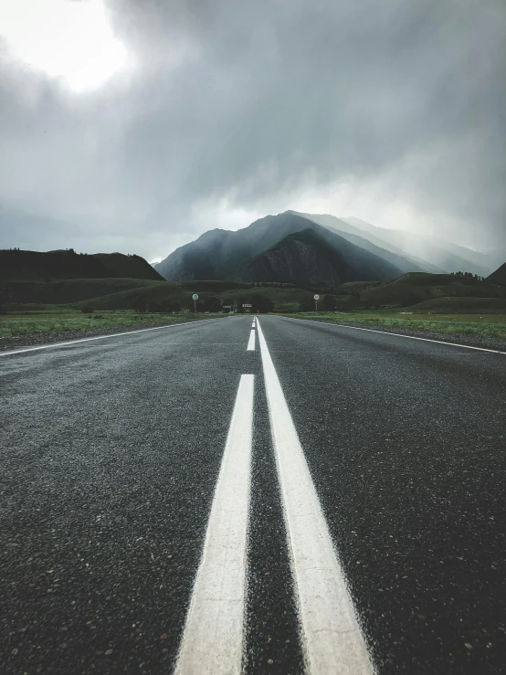 two straight white lines on the middle of an open road