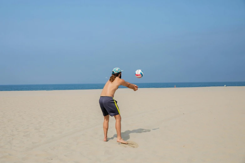 a man throwing a frisbee on the beach