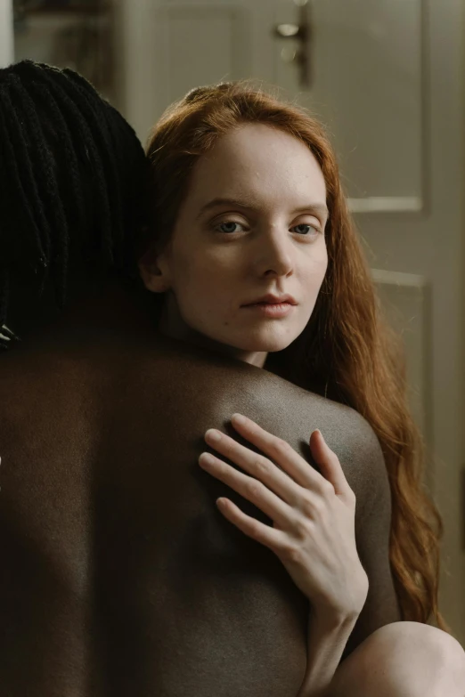 a red - headed girl in a very long veil hugging another woman